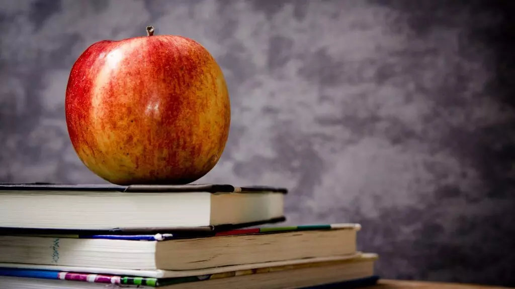 An apple on a stack of books.